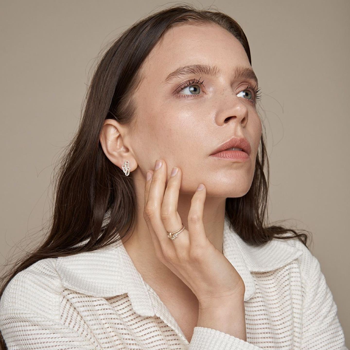 Model wearing handmade geometric silver stud earrings and ring.