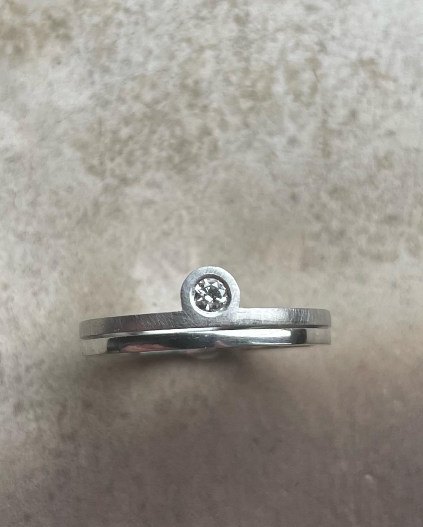 Front view of a slim silver stone-set ring.